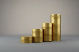 Ascending staircase of gold coin stacks on a soft gray background, symbolizing disciplined, consistent reinvestment for entrepreneurial growth.