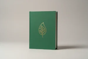 Forest-green book with gold leaf and circuit motif on soft gray background, symbolizing sustainable finance learning.