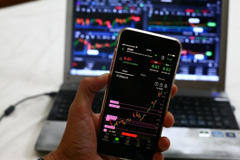 A person analyzing financial data on multiple screens in a modern office setting