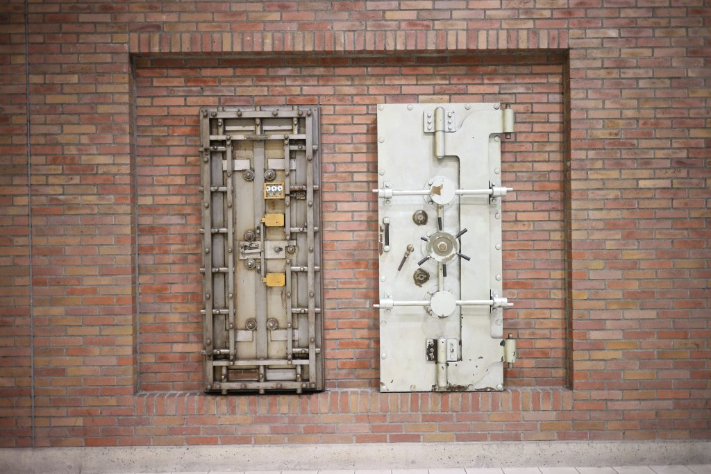 Two heavy steel vault doors set in a brick wall
