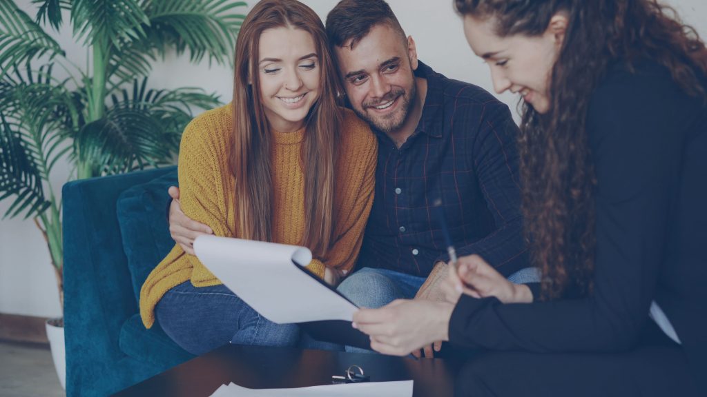 A couple reviews paperwork with a financial adviser