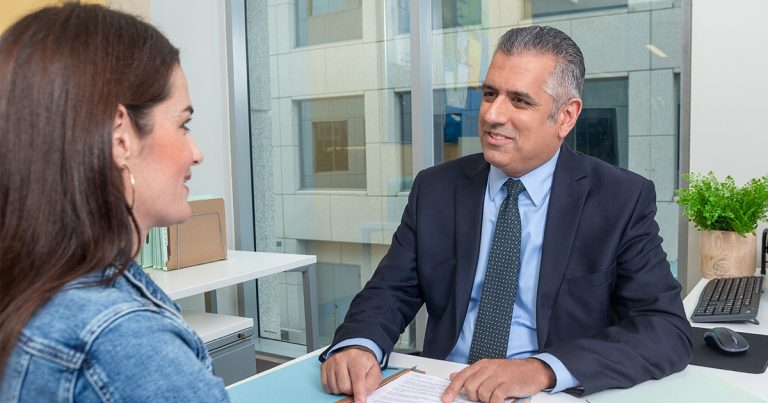A financial advisor reviews paperwork with a client in a bright office