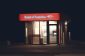 Illuminated Bank of America ATM structure against a dark nighttime backdrop in Boston