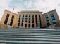From below of Federal Reserve building exterior against USA flags and staircase under cloudy sky in town