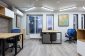 Desks and blue chairs in an office at dusk