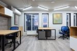 Desks and blue chairs in an office at dusk